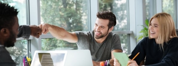 smiling-young-colleagues-sitting-office-coworking